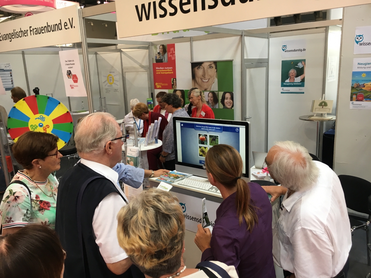 Mehrere Personen schauen auf einen Bildschirm, auf dem Doppeltixx gezeigt wird.