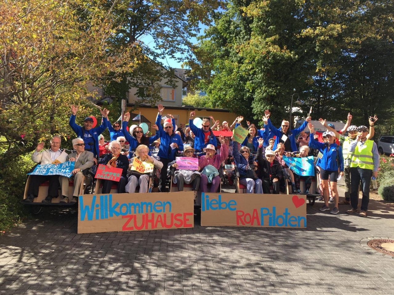 Gruppenfoto mit Rikschas, in denen die Senioren sitzen und winken