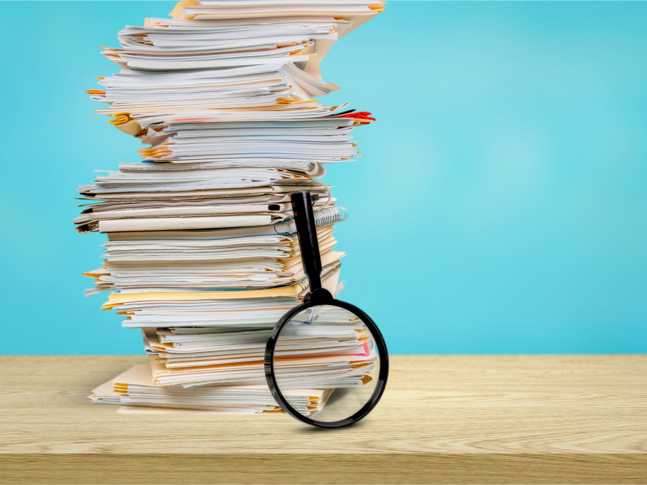 Aktenstapel mit Lupe