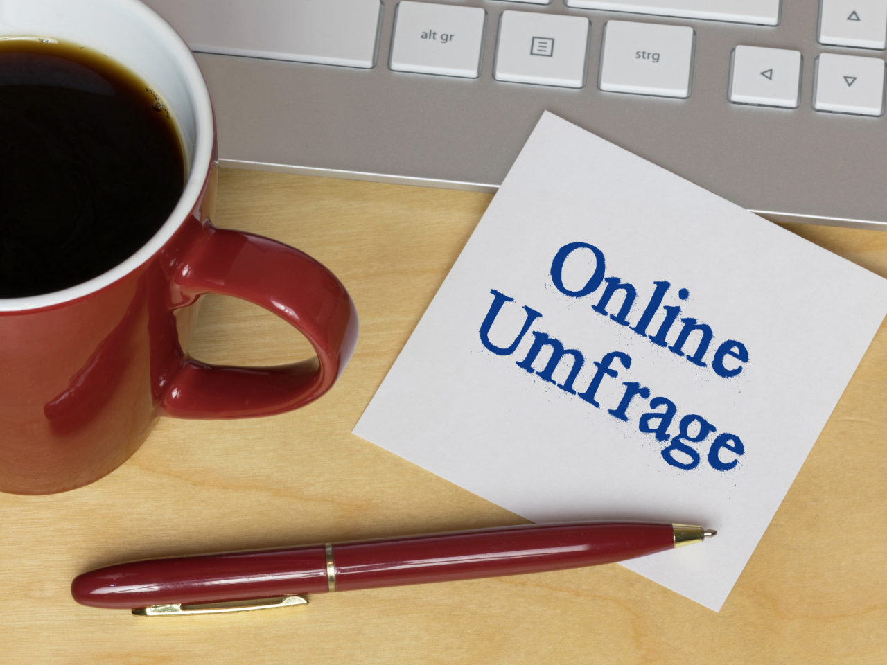 Laptop, Kaffeetasse und Notizzettel "Online Umfrage"